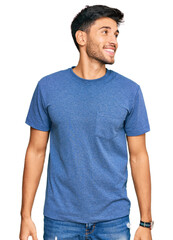 Fototapeta premium Young handsome man wearing casual clothes looking away to side with smile on face, natural expression. laughing confident.