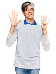 Young hispanic man wearing casual clothes showing and pointing up with fingers number nine while smiling confident and happy.
