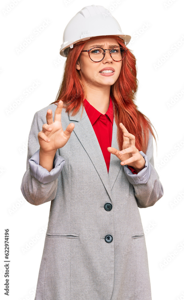 Sticker Young redhead woman wearing architect hardhat disgusted expression, displeased and fearful doing disgust face because aversion reaction. with hands raised