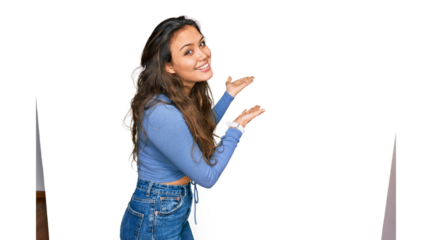 Young hispanic girl wearing casual clothes inviting to enter smiling natural with open hand