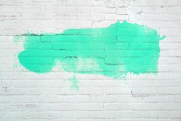 Graffiti Farbe in grün auf weißer Backsteinwand