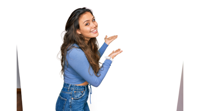 Young hispanic girl wearing casual clothes inviting to enter smiling natural with open hand