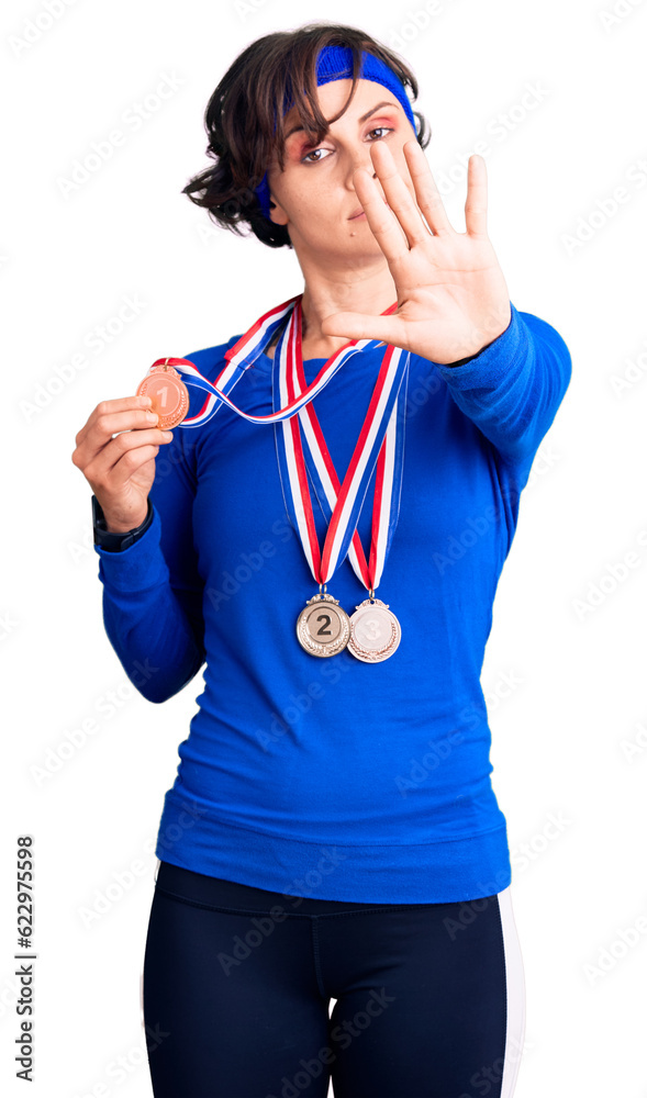 Sticker beautiful young woman with short hair wearing winner medals with open hand doing stop sign with seri