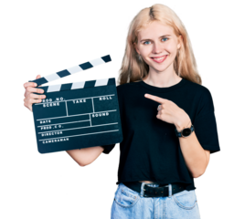 Young caucasian woman holding video film clapboard smiling happy pointing with hand and finger