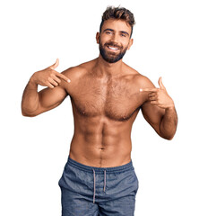 Young hispanic man wearing swimwear shirtless looking confident with smile on face, pointing oneself with fingers proud and happy.