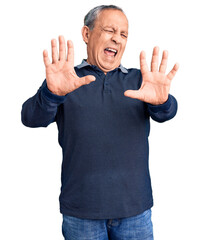 Senior handsome man wearing casual polo afraid and terrified with fear expression stop gesture with...