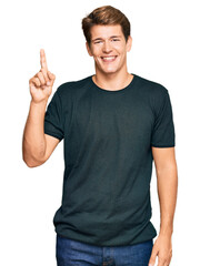 Handsome caucasian man wearing casual clothes showing and pointing up with finger number one while smiling confident and happy.
