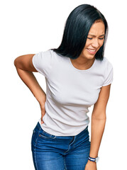 Obraz premium Beautiful hispanic woman wearing casual white tshirt suffering of backache, touching back with hand, muscular pain