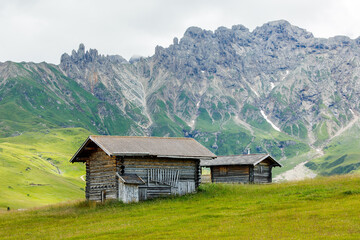Fototapeta na wymiar Huts in the valley of Alpe di Suisi mountains in South Tyrol, Italy.