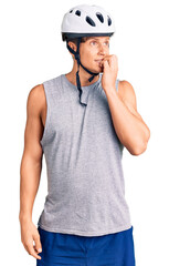Young handsome man wearing bike helmet looking stressed and nervous with hands on mouth biting nails. anxiety problem.