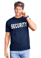 Young handsome man wearing security t shirt mouth and lips shut as zip with fingers. secret and silent, taboo talking