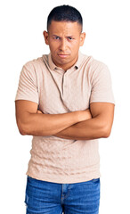 Fototapeta premium Young handsome latin man wearing casual clothes skeptic and nervous, disapproving expression on face with crossed arms. negative person.