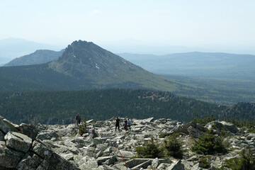 Panorama, landscape. In the foreground are rocks covered with moss, in the background are mountains. Summer, blue sky, day.