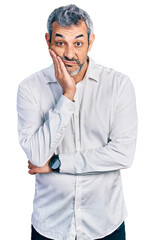 Middle age hispanic with grey hair wearing casual white shirt thinking looking tired and bored with depression problems with crossed arms.