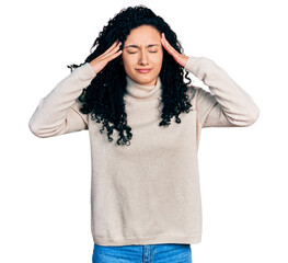 Young hispanic woman with curly hair wearing turtleneck sweater with hand on head, headache because stress. suffering migraine.