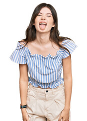 Obraz premium Young beautiful caucasian girl wearing casual clothes sticking tongue out happy with funny expression. emotion concept.
