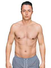 Fototapeta premium Handsome young man wearing swimwear shirtless depressed and worry for distress, crying angry and afraid. sad expression.