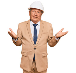 Senior caucasian man wearing architect hardhat clueless and confused expression with arms and hands raised. doubt concept.