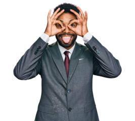 Young african american man wearing business clothes doing ok gesture like binoculars sticking tongue out, eyes looking through fingers. crazy expression.