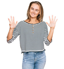 Beautiful blonde woman wearing casual clothes showing and pointing up with fingers number nine while smiling confident and happy.