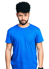 Obraz premium Young arab man with beard wearing casual blue t shirt skeptic and nervous, frowning upset because of problem. negative person.