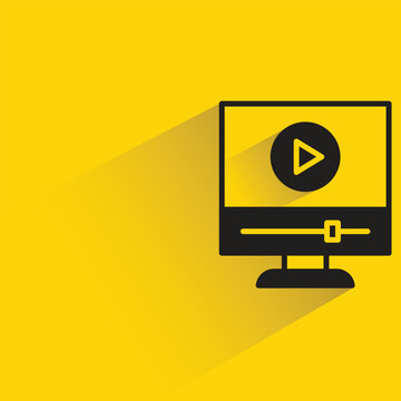 video on desktop computer with shadow on yellow background