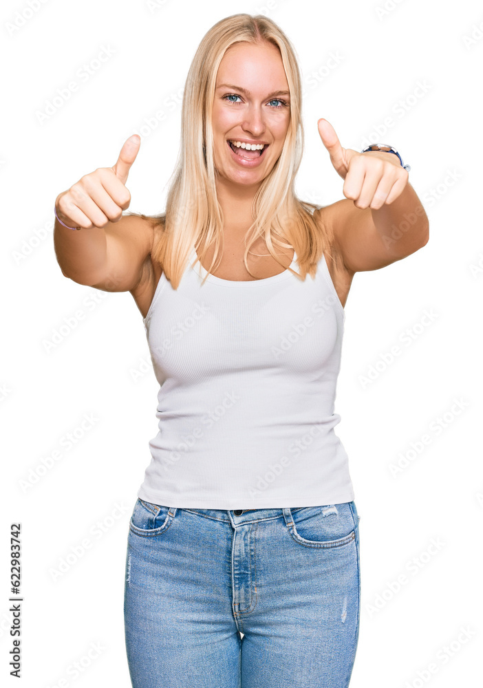 Canvas Prints Young blonde girl wearing casual style with sleeveless shirt approving doing positive gesture with hand, thumbs up smiling and happy for success. winner gesture.