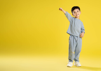 full body image of boy posing on a yellow background. © STOCK88PHOTOGRAPHER