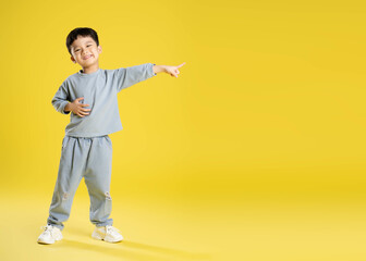 Fototapeta na wymiar full body image of boy posing on a yellow background.