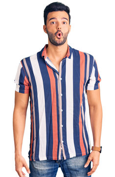 Young handsome hispanic man wearing casual  summer shirt scared and amazed with open mouth for surprise, disbelief face