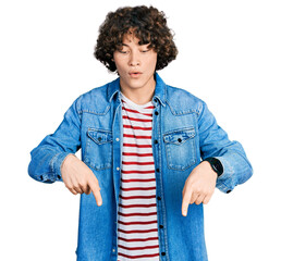 Caucasian teenager wearing casual clothes pointing down with fingers showing advertisement, surprised face and open mouth © Krakenimages.com
