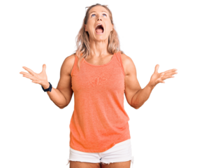 Middle age fit blonde woman wearing casual summer clothes and sunglasses crazy and mad shouting and yelling with aggressive expression and arms raised. frustration concept.