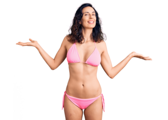 Young beautiful hispanic woman wearing bikini smiling showing both hands open palms, presenting and advertising comparison and balance