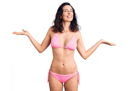 Young beautiful hispanic woman wearing bikini smiling showing both hands open palms, presenting and advertising comparison and balance