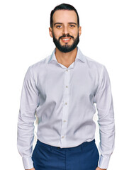 Fototapeta premium Young man with beard wearing business shirt with a happy and cool smile on face. lucky person.