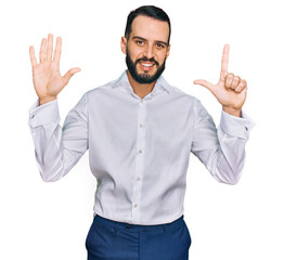 Young man with beard wearing business shirt showing and pointing up with fingers number seven while smiling confident and happy.