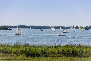 Sailboats and sloops on the lake the Kaag on a sunny day in the Netherlands.