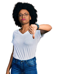 Young african american woman wearing casual white t shirt looking unhappy and angry showing rejection and negative with thumbs down gesture. bad expression.
