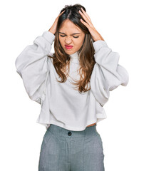 Young brunette woman wearing casual turtleneck sweater suffering from headache desperate and stressed because pain and migraine. hands on head.