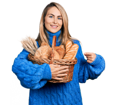Young blonde woman holding wicker basket with bread smiling happy pointing with hand and finger