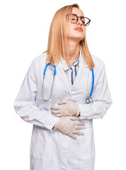 Beautiful caucasian woman wearing doctor uniform and stethoscope with hand on stomach because nausea, painful disease feeling unwell. ache concept.