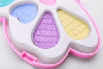 Decorative cosmetics for kids. Eye shadow palette on white table, closeup