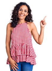 Middle age beautiful woman wearing casual sleeveless t shirt smiling happy pointing with hand and finger to the side