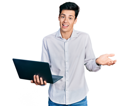Young hispanic business man working using computer laptop celebrating achievement with happy smile and winner expression with raised hand