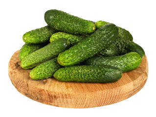 Fresh cucumbers on round wooden board, transparent background