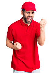 Young handsome man with beard wearing delivery uniform celebrating surprised and amazed for success with arms raised and eyes closed. winner concept.