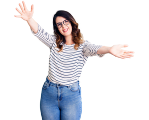 Beautiful young brunette woman wearing casual clothes and glasses looking at the camera smiling with open arms for hug. cheerful expression embracing happiness.