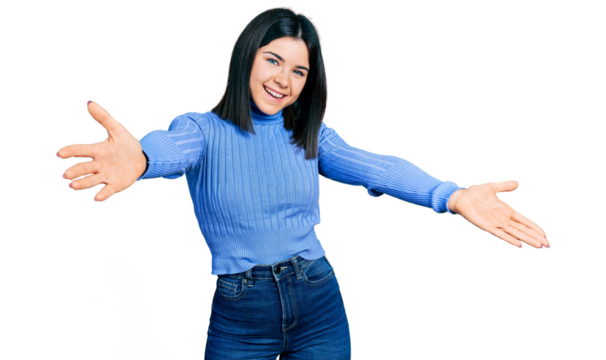 Young brunette woman with blue eyes wearing casual turtleneck sweater looking at the camera smiling with open arms for hug. cheerful expression embracing happiness.