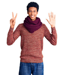 Young african american man wearing casual winter sweater and scarf showing and pointing up with fingers number seven while smiling confident and happy.