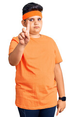 Little boy kid wearing sportswear pointing with finger up and angry expression, showing no gesture